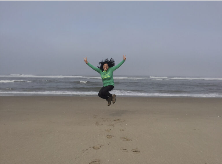 woman jumping on beach in Oregon